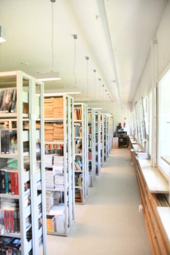 Półki ze zbiorami bibliotecznymi.